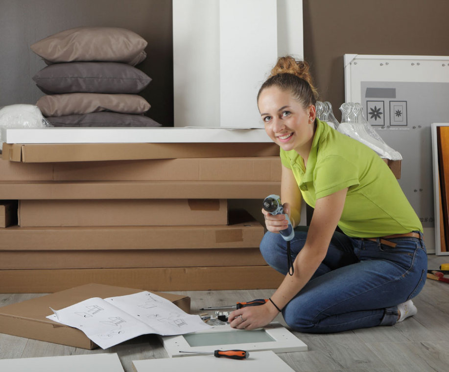 Jeune femme assemble un meuble en kit
